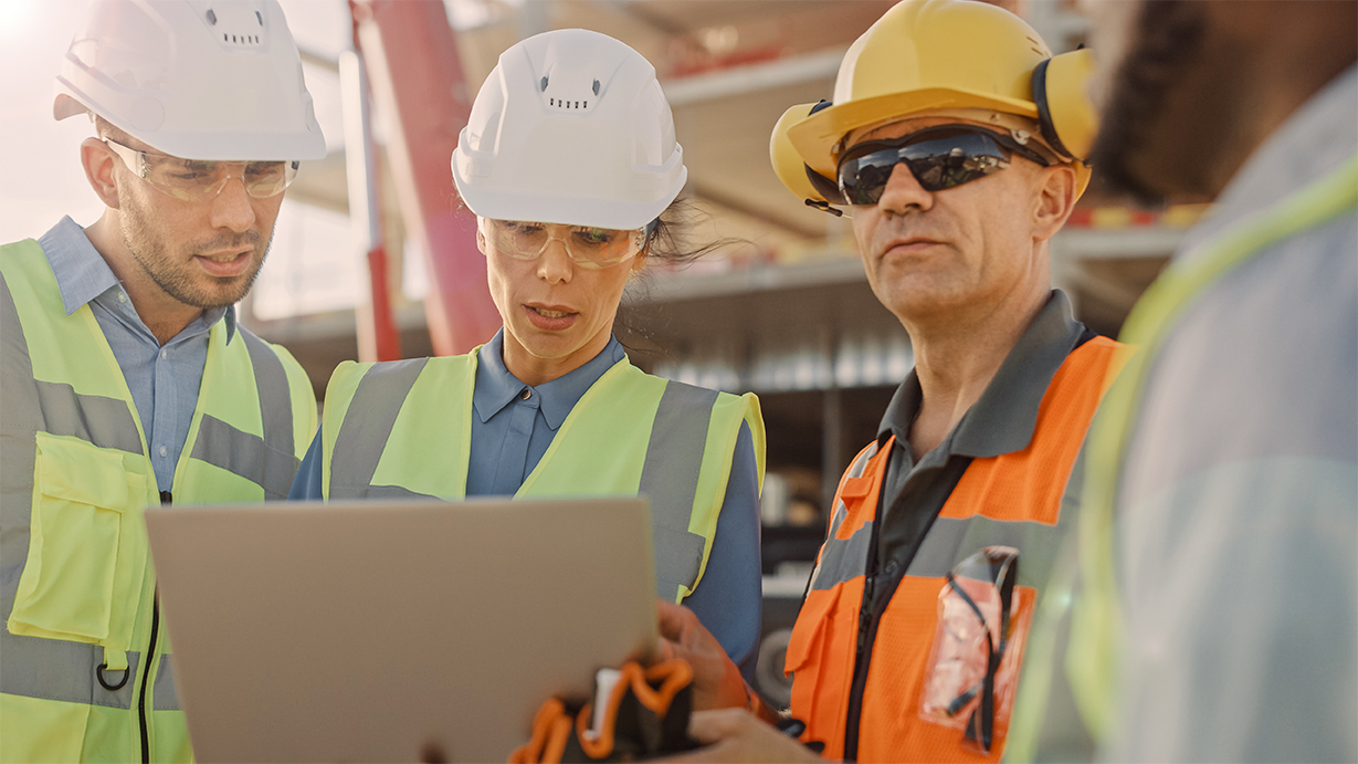 Diverse Team of Specialists Use Laptop Computer on Construction